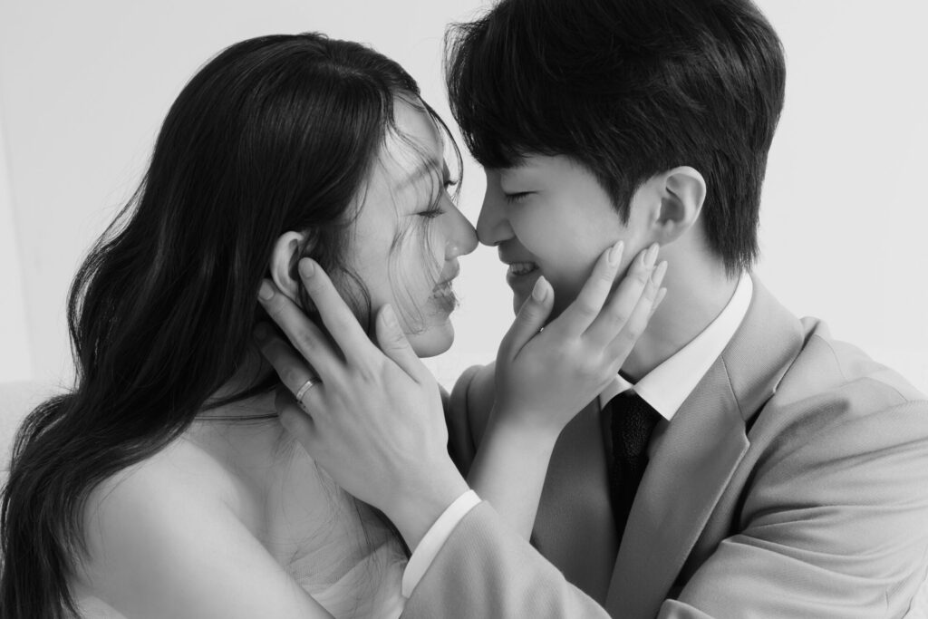 Bride and groom smiling and touching foreheads during a minimal black and white wedding photoshoot